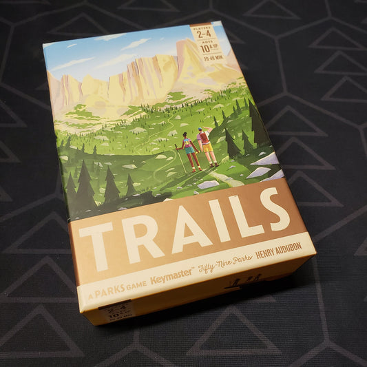 Image shows the front cover of the box for the Trails board game