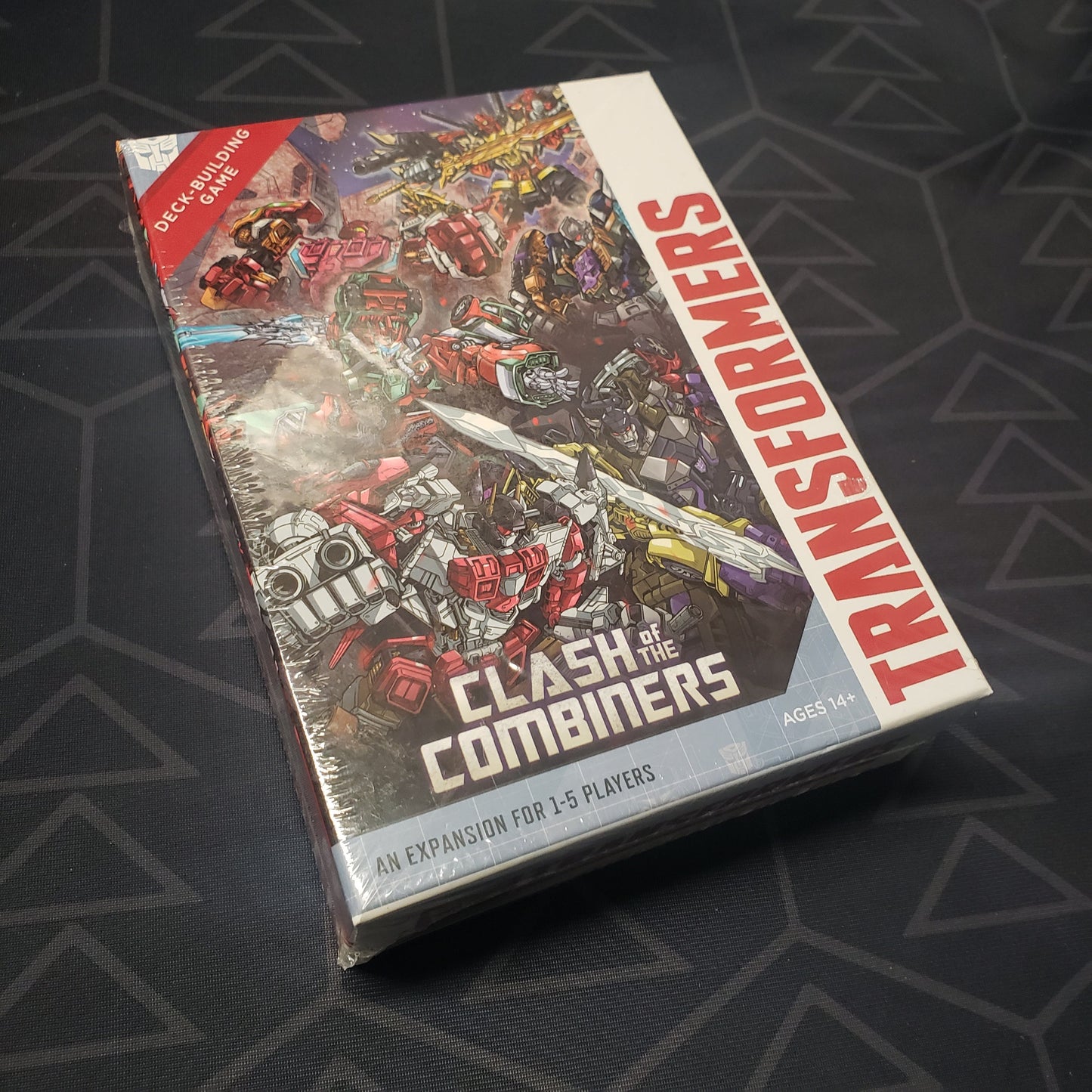 Image shows the front cover of the box of the Clash of the Combiners expansion for the card game Transformers Deck-Building Game