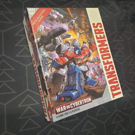 Image shows the front cover of the box of the War on Cybertron expansion for the card game Transformers Deck-Building Game