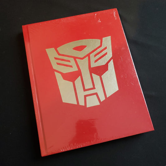 Image shows the front cover of the Deluxe Limited Edition of the Core Rulebook for the Transformers roleplaying game