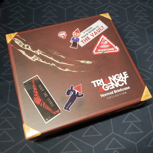 Image shows the front cover of the box of the Normal Briefcase Collection for the roleplaying game Triangle Agency