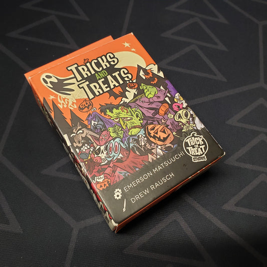 Image shows the front cover of the box for the Tricks and Treats card game