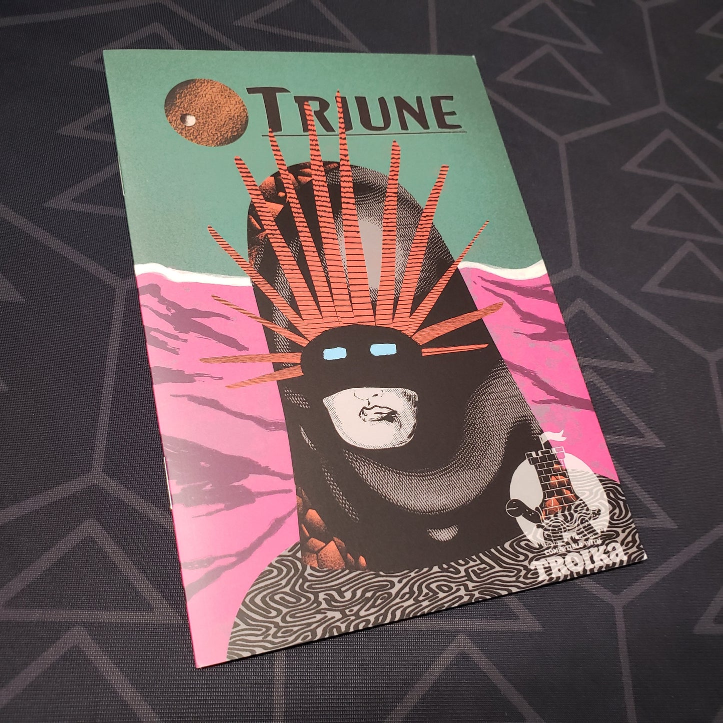 Image shows the front cover of the Triune roleplaying game book