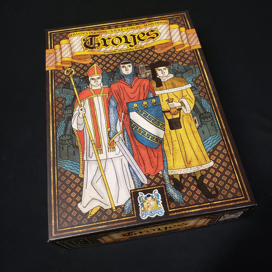 Image shows the front cover of the box of the Troyes board game