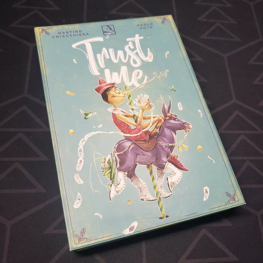 Image shows the front cover of the box for the Trust Me card game