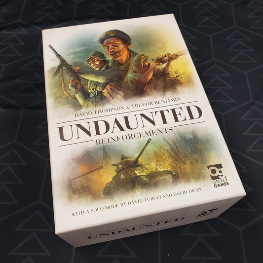 Image shows the front cover of the box of the Reinforcements expansion for the board game series Undaunted
