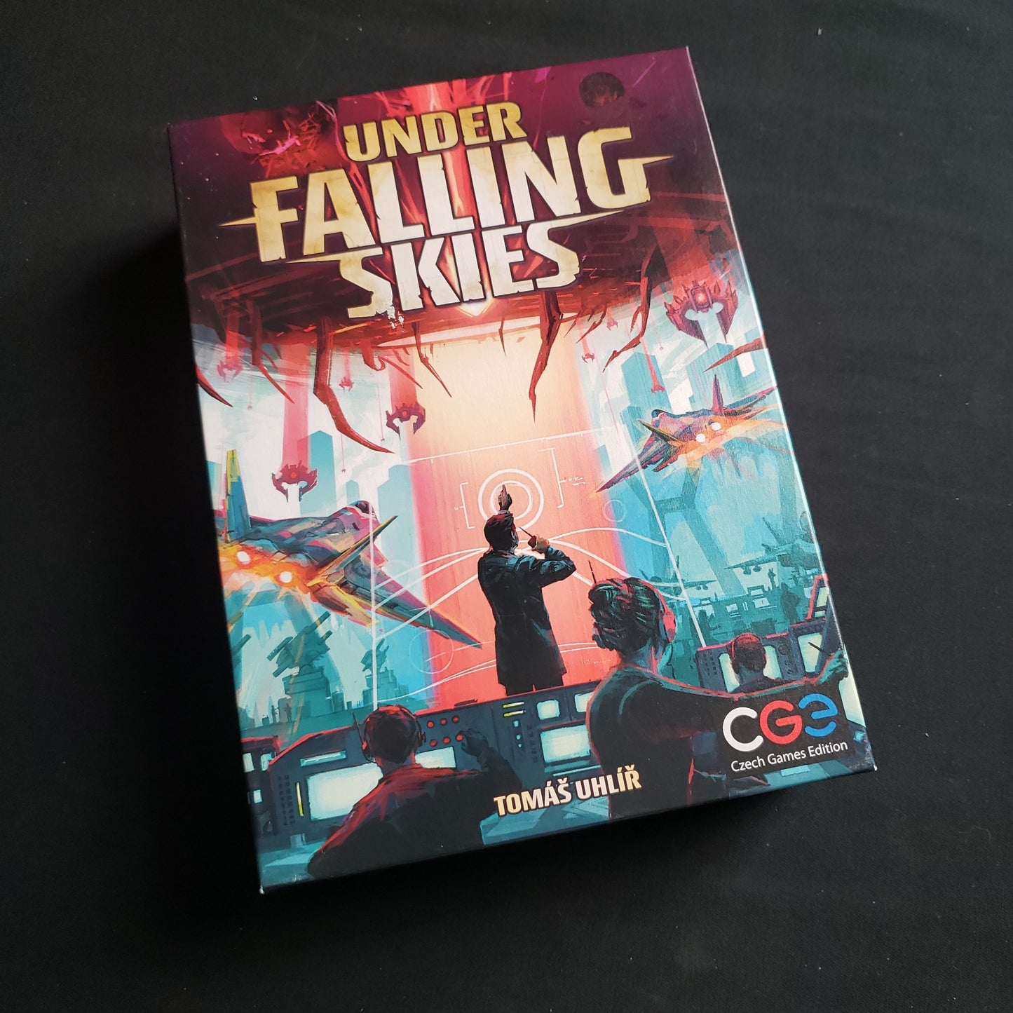 Image shows the front cover of the box of the Under Falling Skies board game