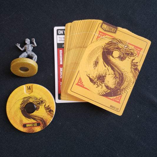 Image shows the miniature and cards for the Bruce Lee expansion for the board game Unmatched