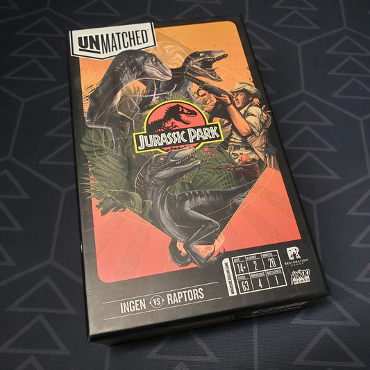 Image shows the front cover of the box of the board game Unmatched Jurassic Park: Ingen vs Raptors
