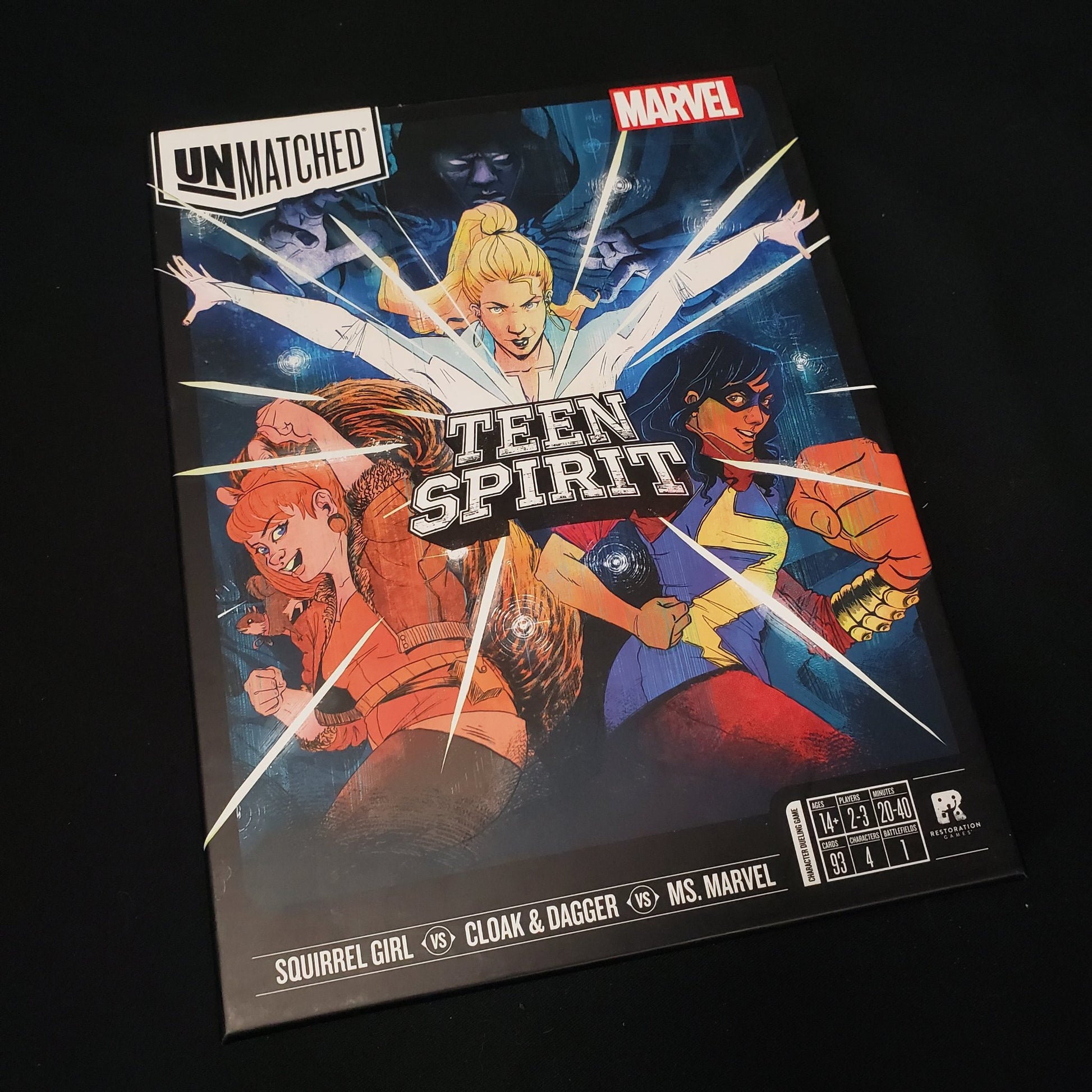 Image shows the front cover of the box of the Unmatched: Teen Spirit board game