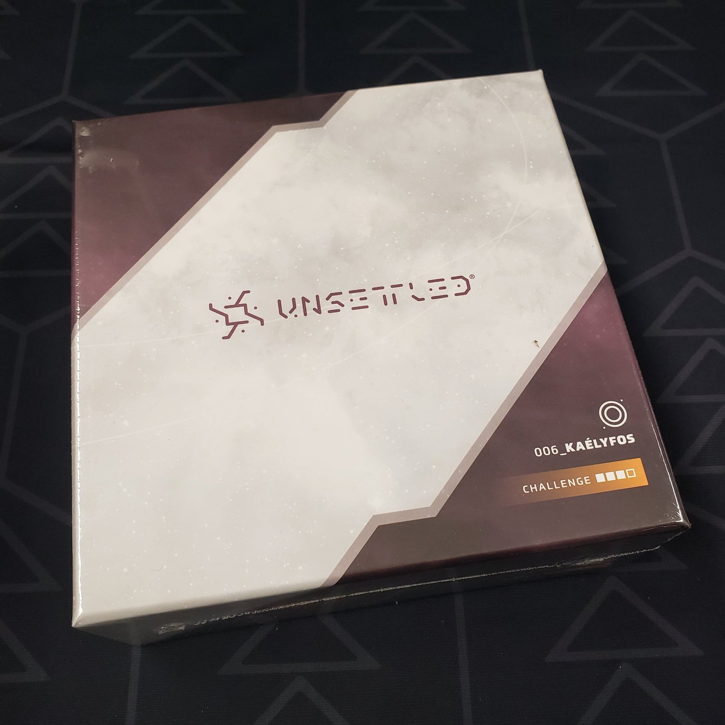 Image shows the front of the box for the Kaelyfos expansion for the board game Unsettled