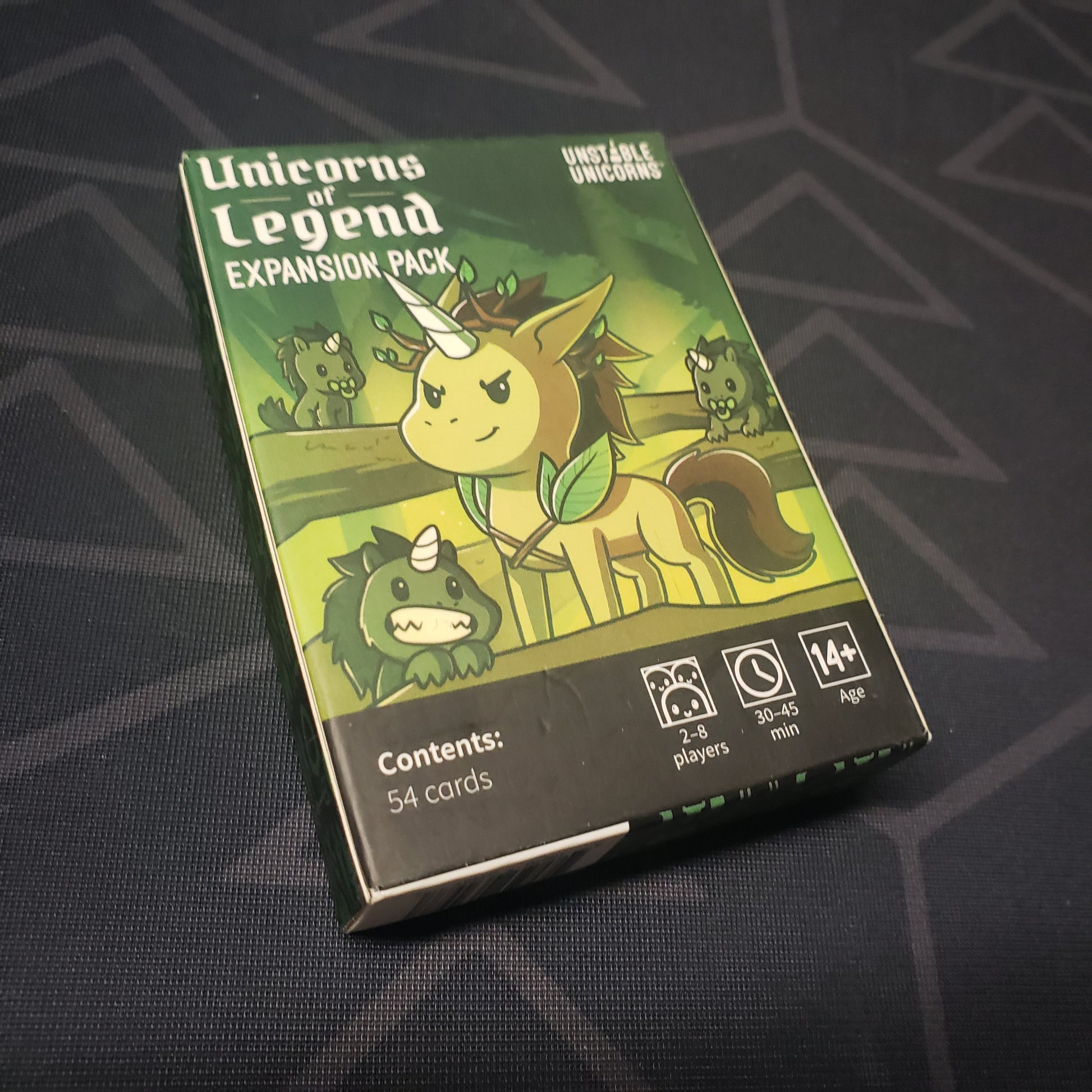 Image shows the front cover of the box of the Unicorns of Legend expansion for the card game Unstable Unicorns