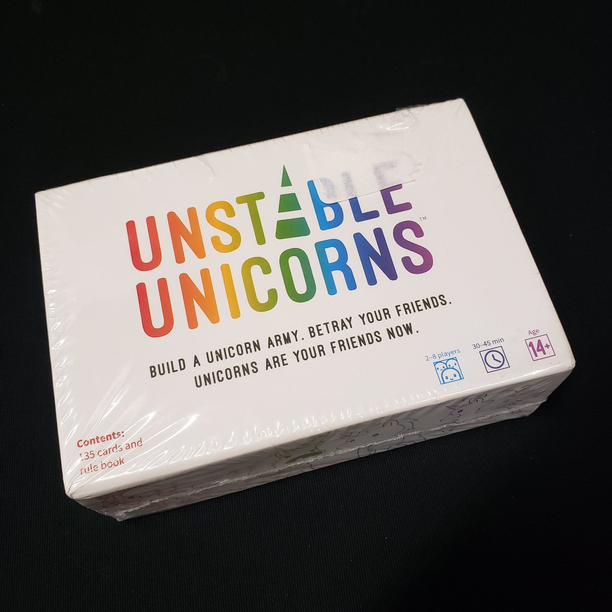 Image shows the front cover of the box of the Unstable Unicorns card game