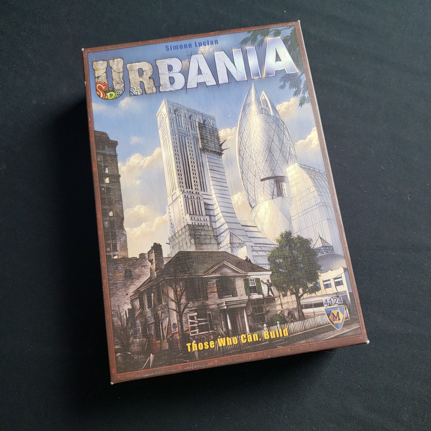 Image shows the front cover of the box of the Urbania board game