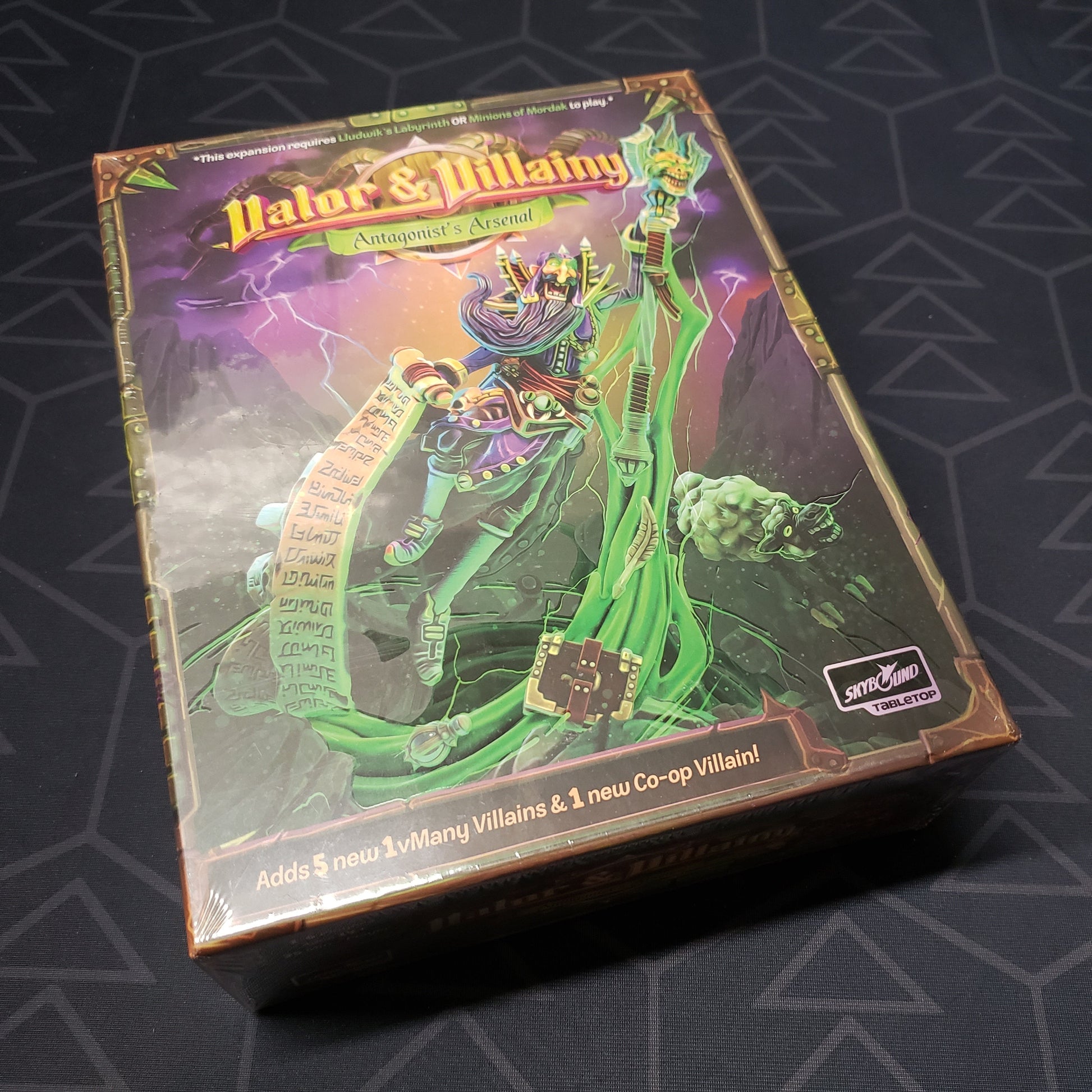 Image shows the front cover of the box of the Antagonist's Arsenal expansion for the board game Valor & Villainy