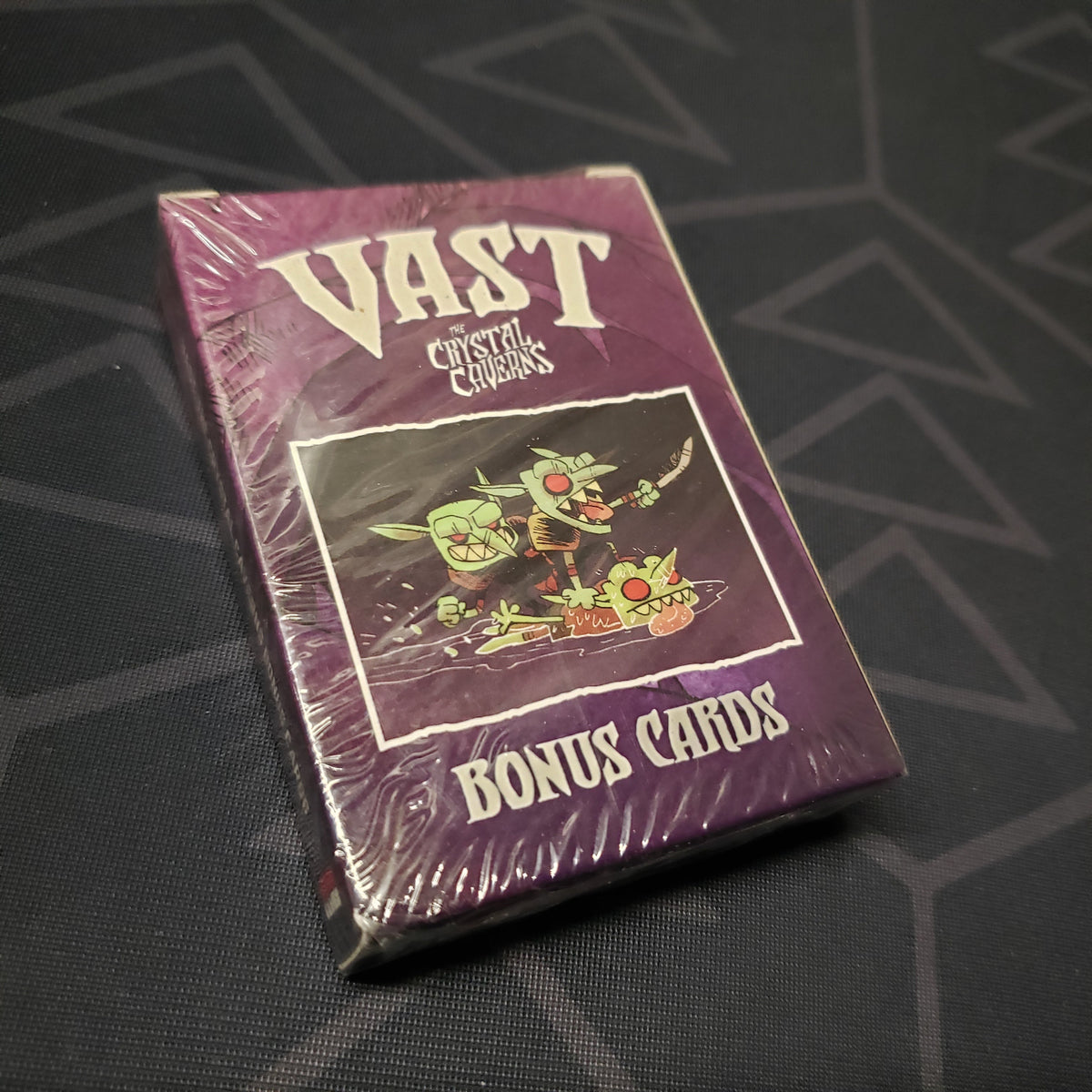 Image shows the front cover of the box of the Bonus Cards expansion for the board game Vast: The Crystal Caverns