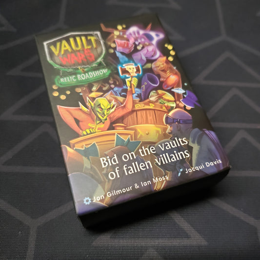 Image shows the front cover of the box of the Relic Roadshow expansion for the card game Vault Wars