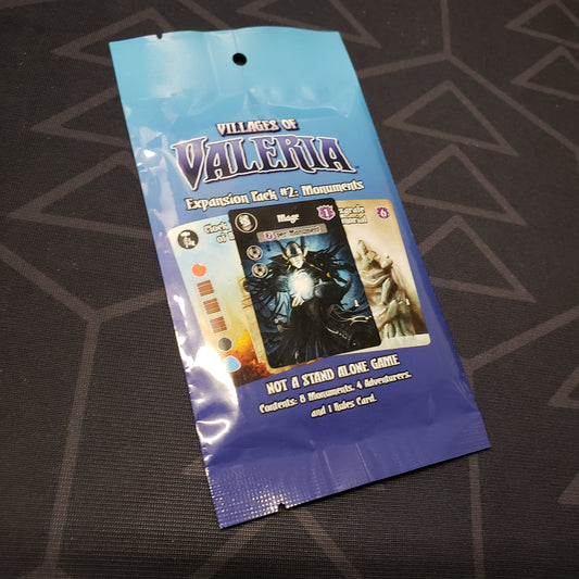 Image shows the front of the packaging of the Monuments expansion for the board game Villages of Valeria