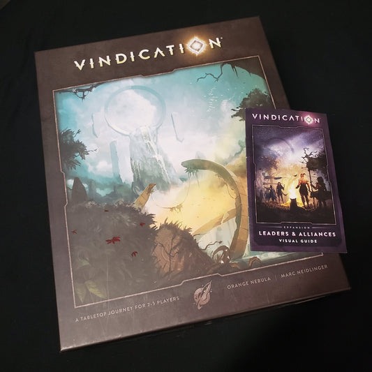 Image shows the front cover of the box of the Vindication board game with the instructions for the Leaders & Alliances expansion sitting on top of it