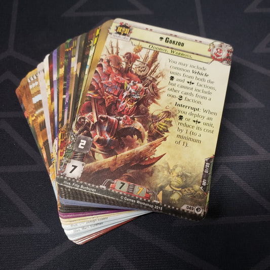 Image shows the cards for the Deadly Salvage expansion for the card game Warhammer 40K Conquest fanned out in a stack
