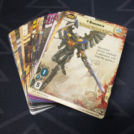 Image shows the cards for the Descendants of Isha expansion for the card game Warhammer 40K Conquest fanned out in a stack