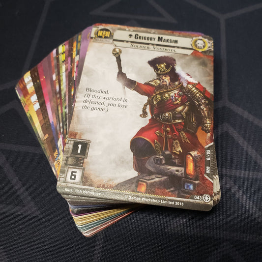 Image shows the cards for the Slash and Burn expansion for the card game Warhammer 40K Conquest fanned out in a stack