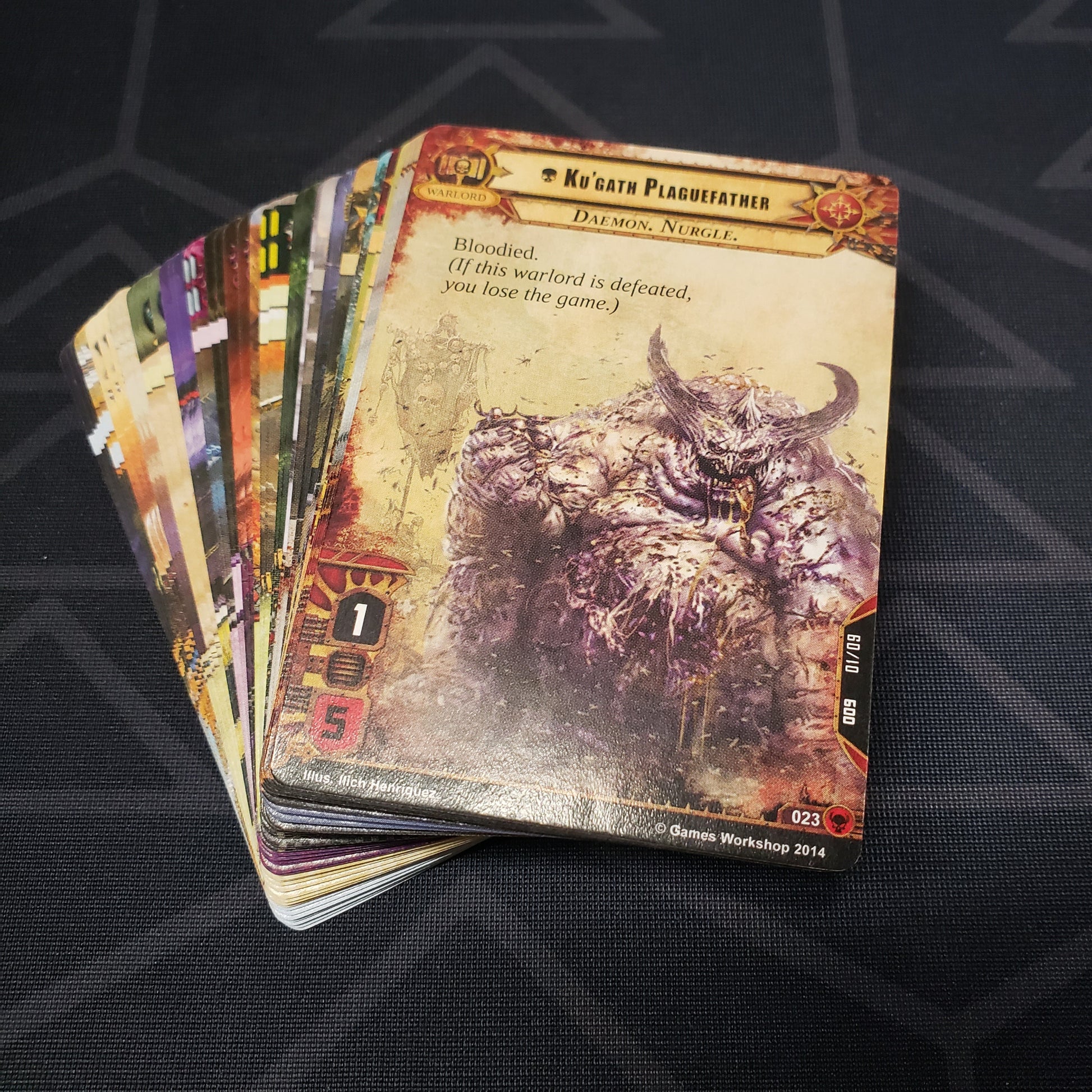 Image shows the cards for the Scourge expansion for the card game Warhammer 40K Conquest fanned out in a stack