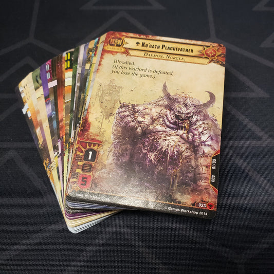 Image shows the cards for the Scourge expansion for the card game Warhammer 40K Conquest fanned out in a stack