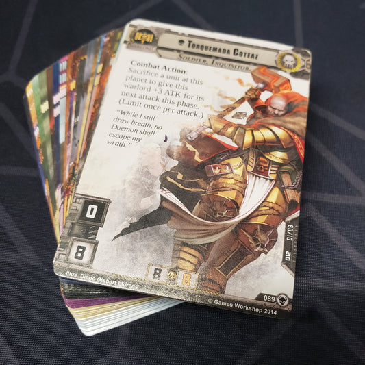 Image shows the cards for the Threat Beyond expansion for the card game Warhammer 40K Conquest fanned out in a stack