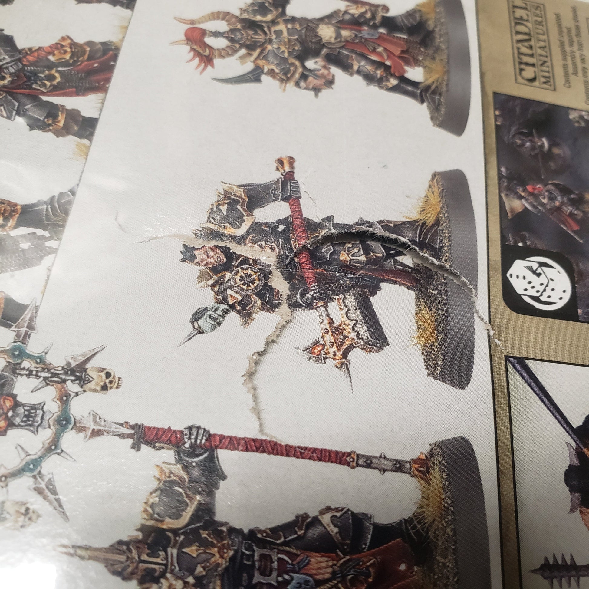 Image shows a small puncture on the back of the box of the Slaves to Darkness: Chaos Chosen pack for the miniatures game Warhammer Age of Sigmar