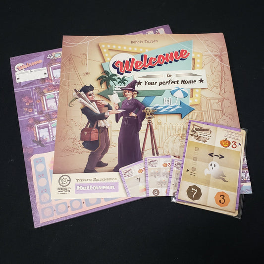 Image shows the score pad, instruction sheet and cards for the Halloween expansion for the board game Welcome To…