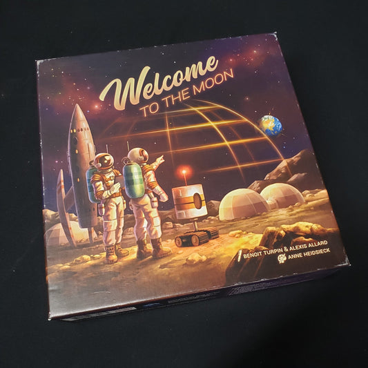 Image shows the front cover of the box of the Welcome to the Moon board game