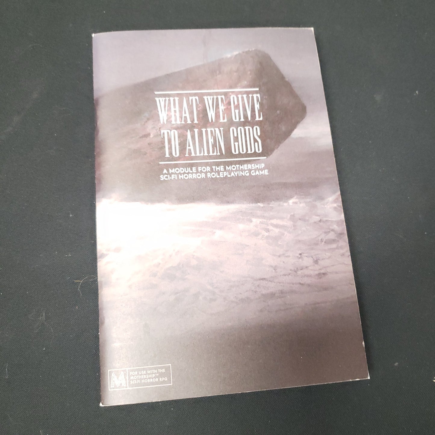 Image shows the front cover of the What We Give to Alien Gods roleplaying game book