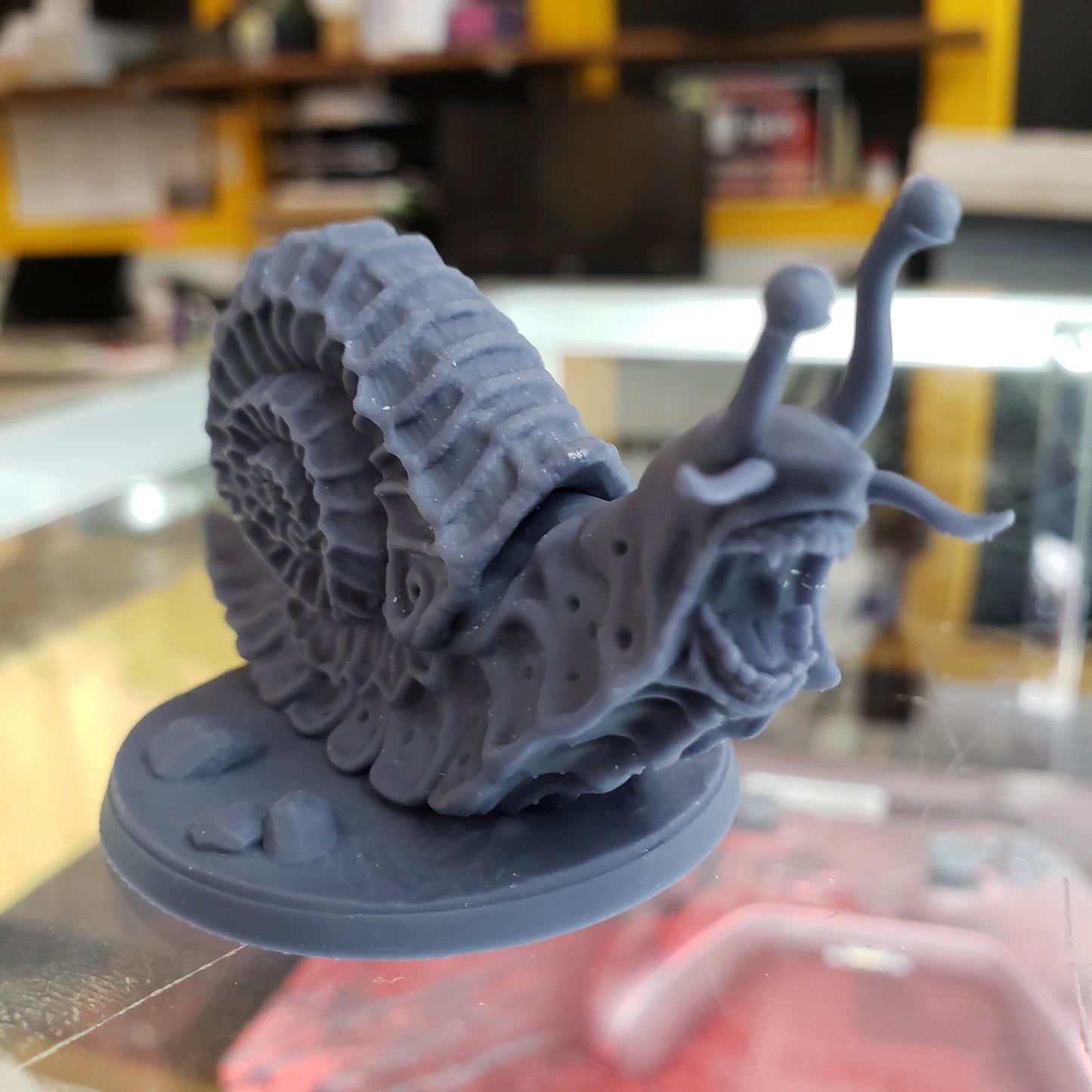 Image shows an example of a 3D printed wild giant snail gaming miniature printed in-house at All Systems Go