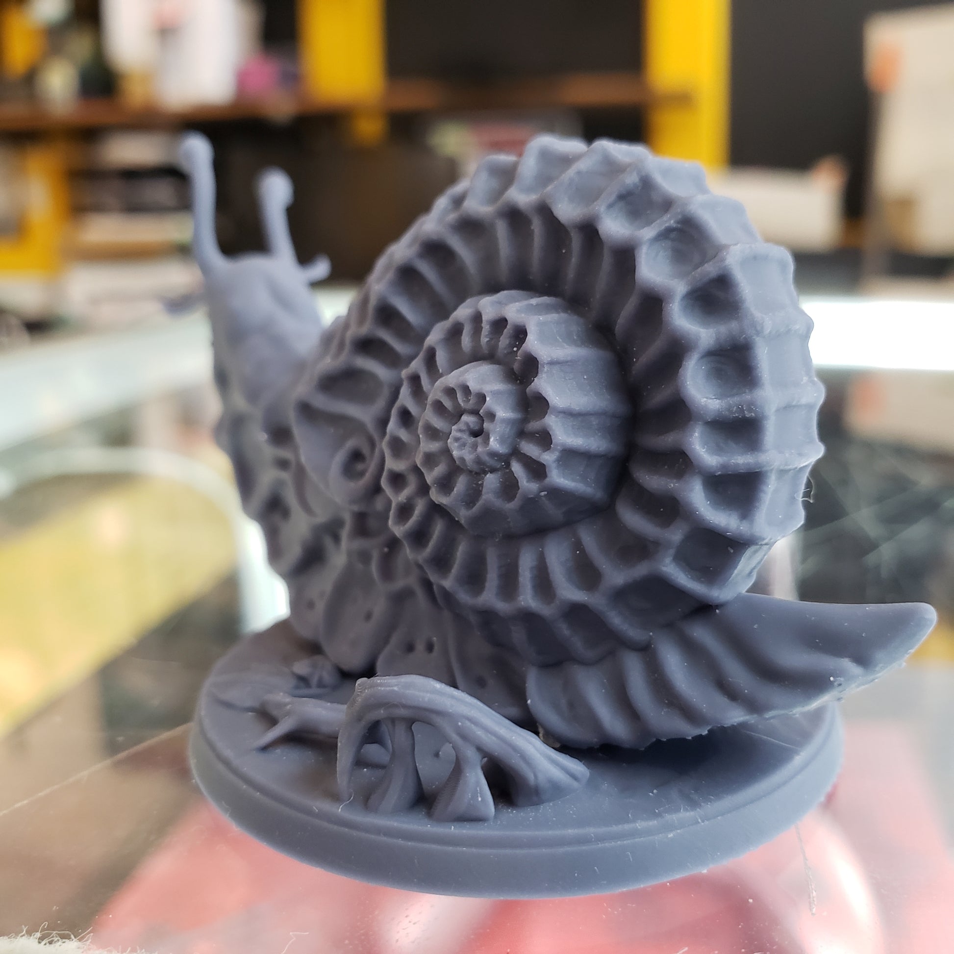 Image shows an example of a 3D printed wild giant snail gaming miniature printed in-house at All Systems Go