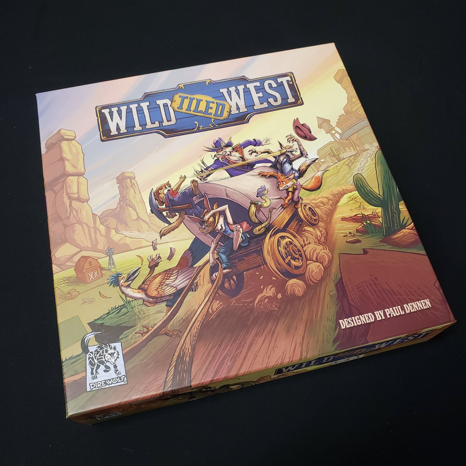 Image shows the front cover of the box of the Wild Tiled West board game