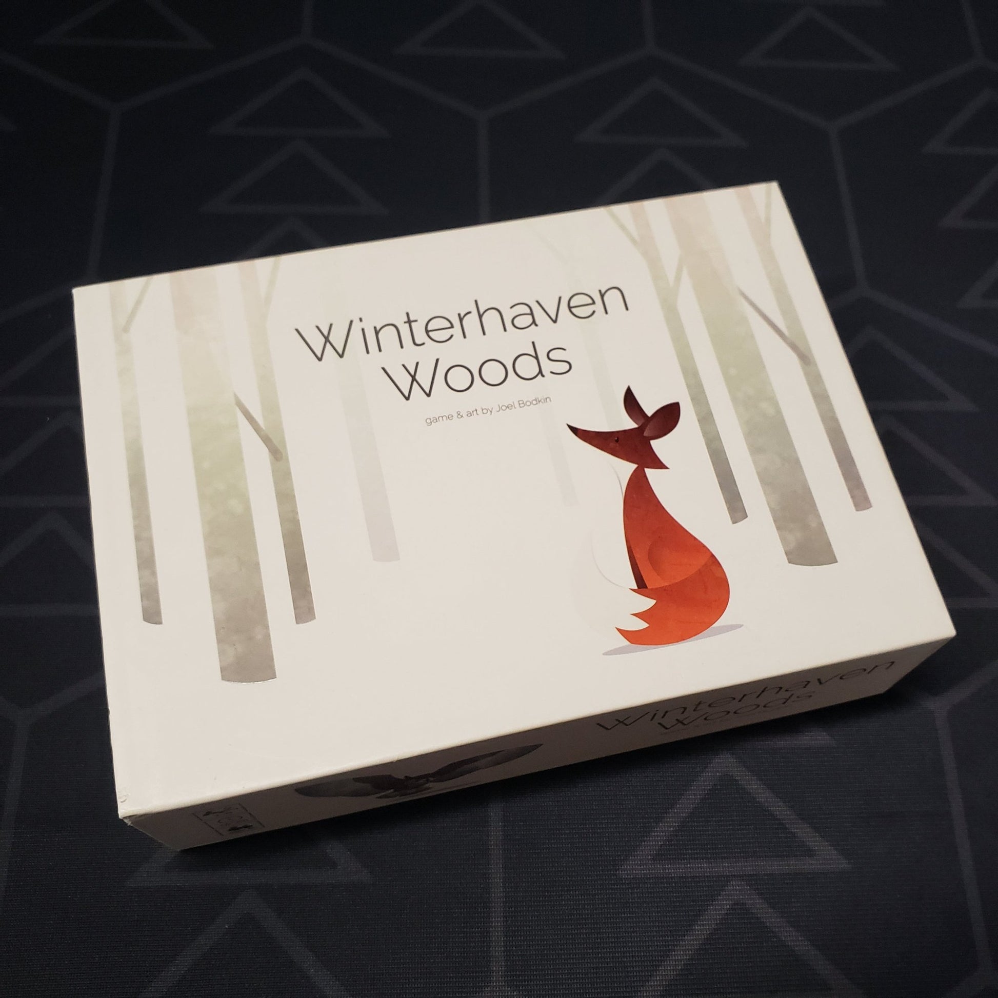 Image shows the front cover of the box of the Winterhaven Woods card game