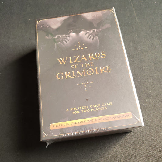 Image shows the front cover of the box of the Wizards Of The Grimoire card game