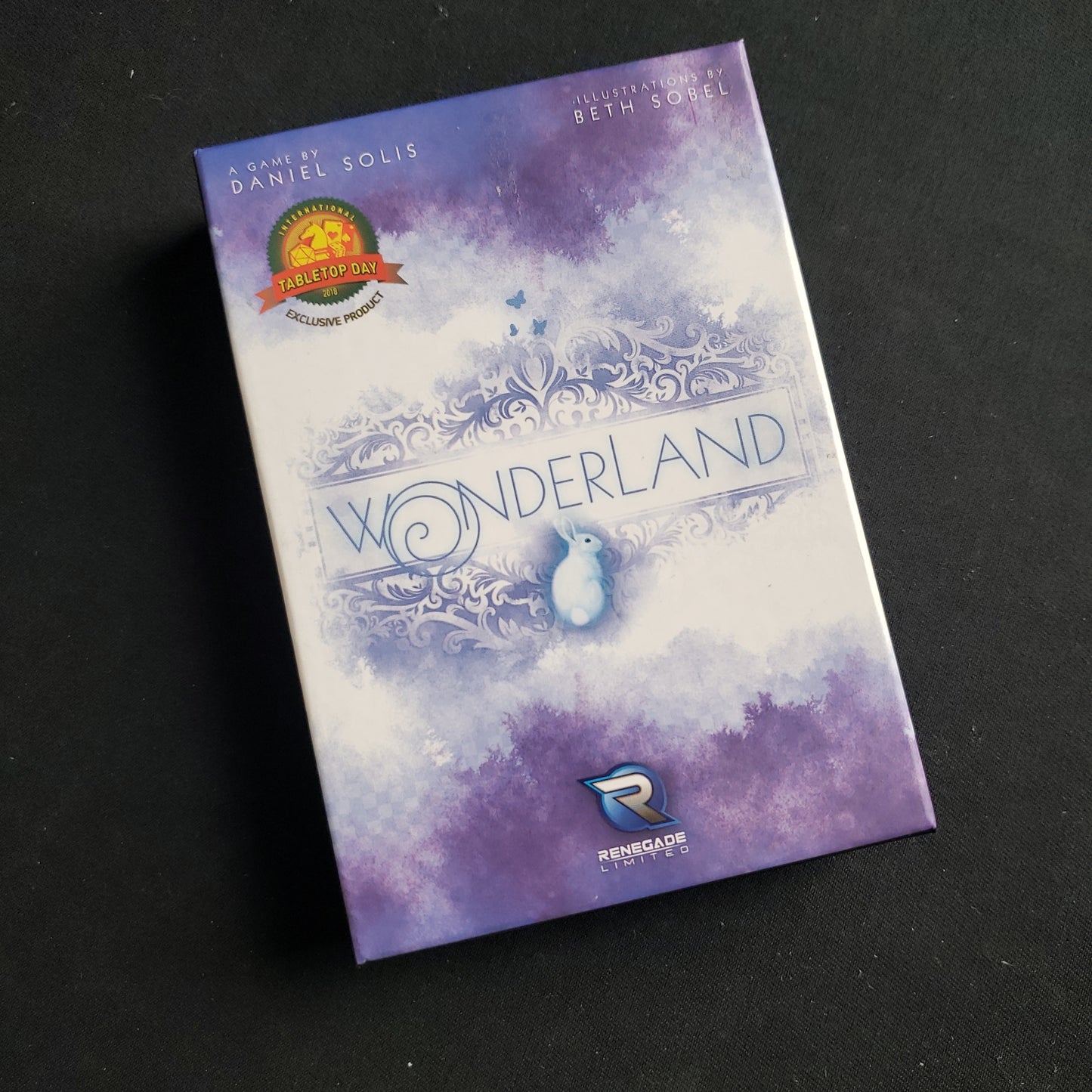 Image shows the front cover of the box of the Wonderland card game