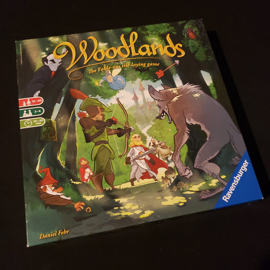 Image shows the front cover of the box of the Woodlands board game