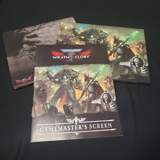 Image shows a scenario book, battlemat, and gamemaster screen for the roleplaying game Wrath & Glory