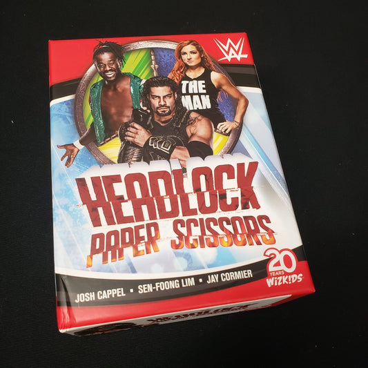 Image shows the front cover of the box of the WWE Headlock Paper Scissors card game