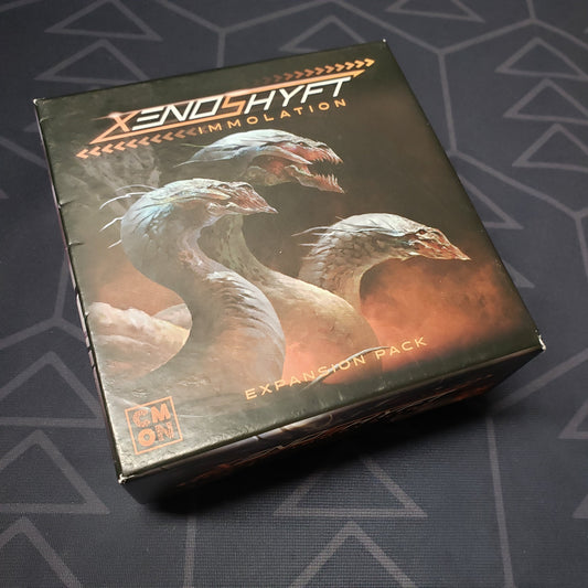 Image shows the front cover of the box of the Immolation expansion for the board games XenoShyft: Onslaught & XenoShyft: Dreadmire