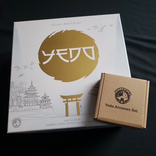 Image shows the front cover of the box of the Yedo: deluxe Master Set board game, with the Annexes Set box sitting on top of it