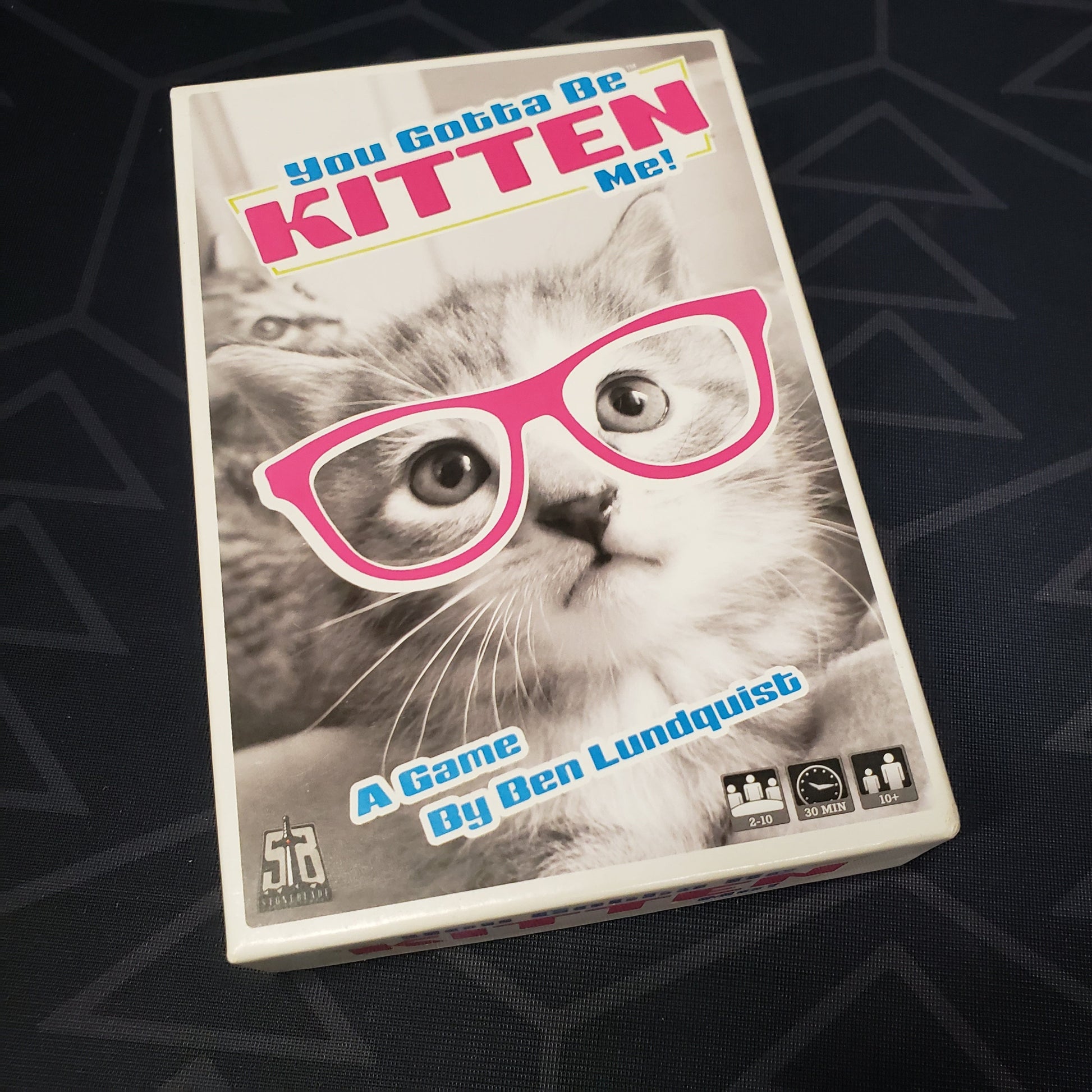 Image shows the front cover of the box of the You Gotta Be Kitten Me! card game