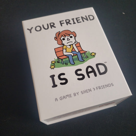 Image shows the front cover of the box of the Your Friend Is Sad card game