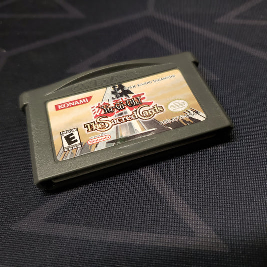Image shows the front of the cartridge for the video game Yu-Gi-Oh!: The Sacred Cards for Nintendo Game Boy Advance