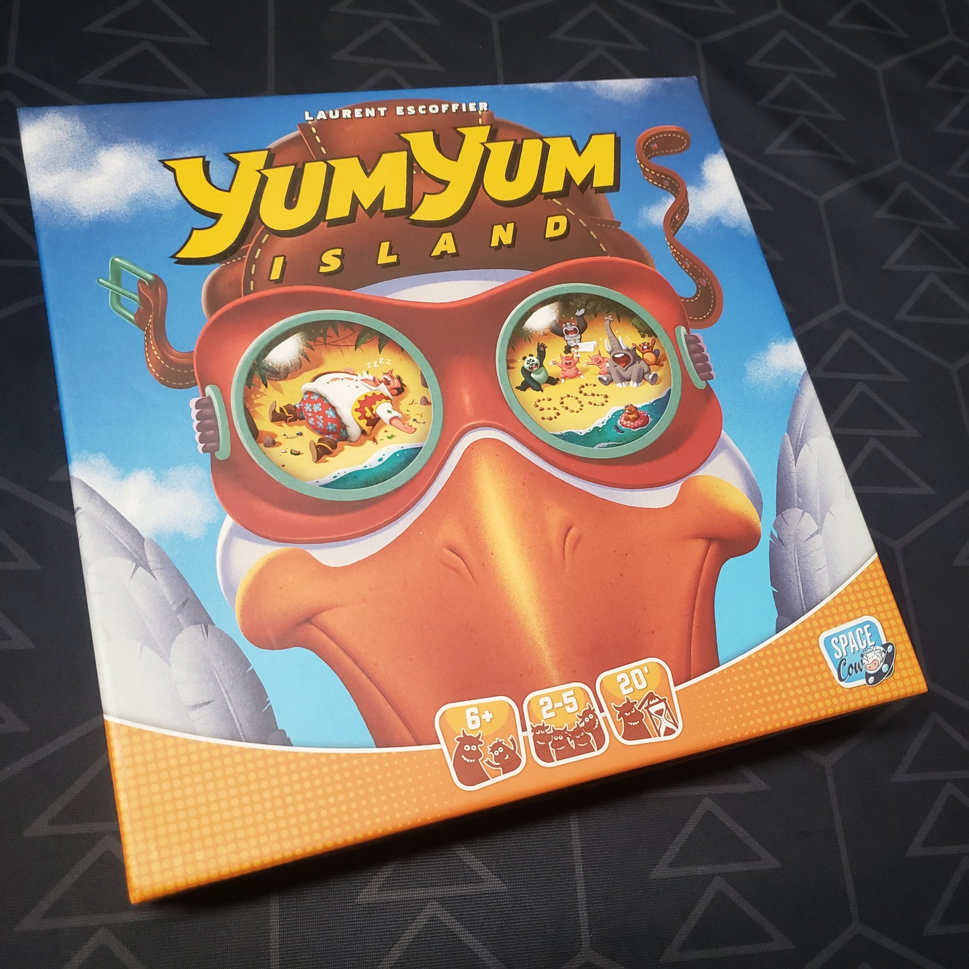 Image shows the front cover of the box for the Yum Yum Island board game