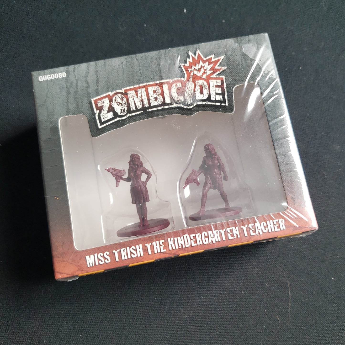 Image shows the front cover of the box of the Miss Trish Survivor expansion pack for the board game Zombicide