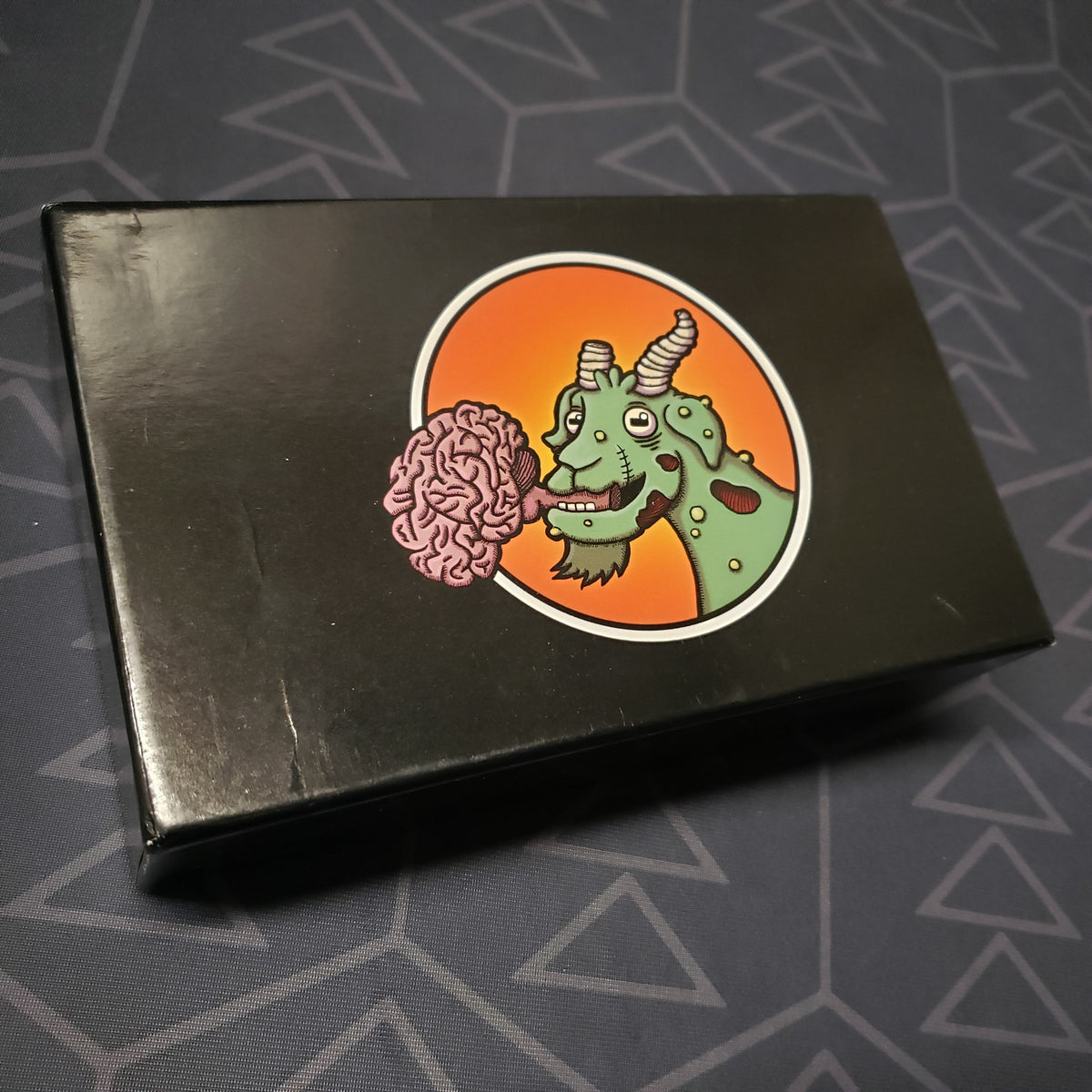 Image shows the front cover of the box for the Zombie Circus Goats card game